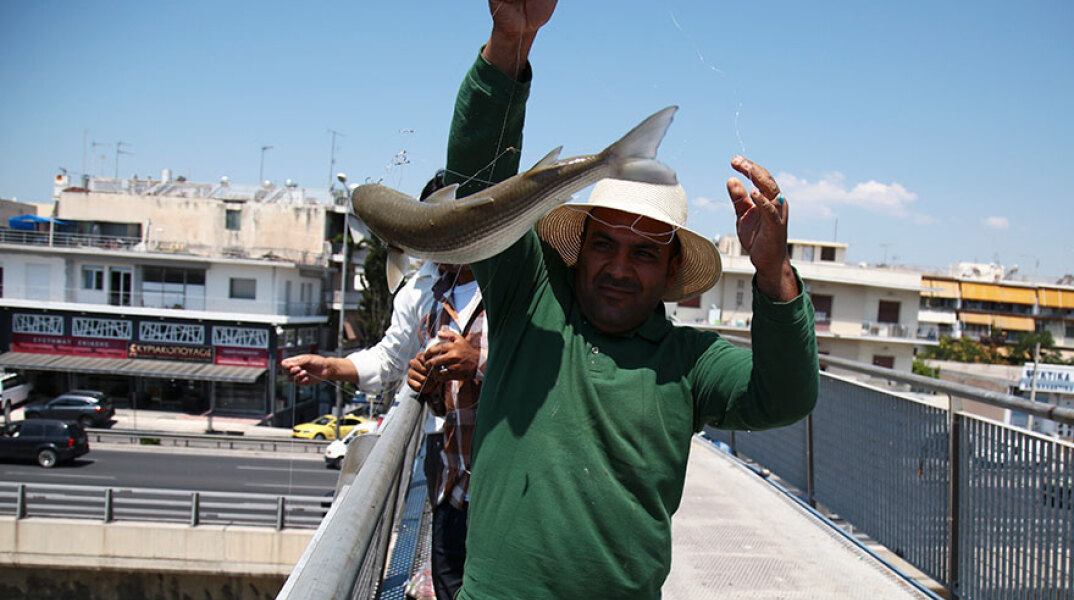 Ψαρεύουν κέφαλους στον Κηφισό από τη γέφυρα στο ύψος του Ρέντη