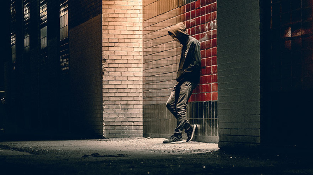 Άνδρας με κουκούλα στο σκοτάδι