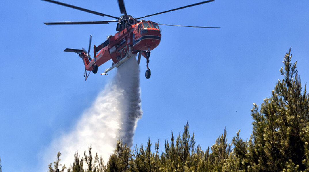 Ελικόπτερο της Πυροσβεστικής ρίχνει νερό σε δασική πυρκαγιά