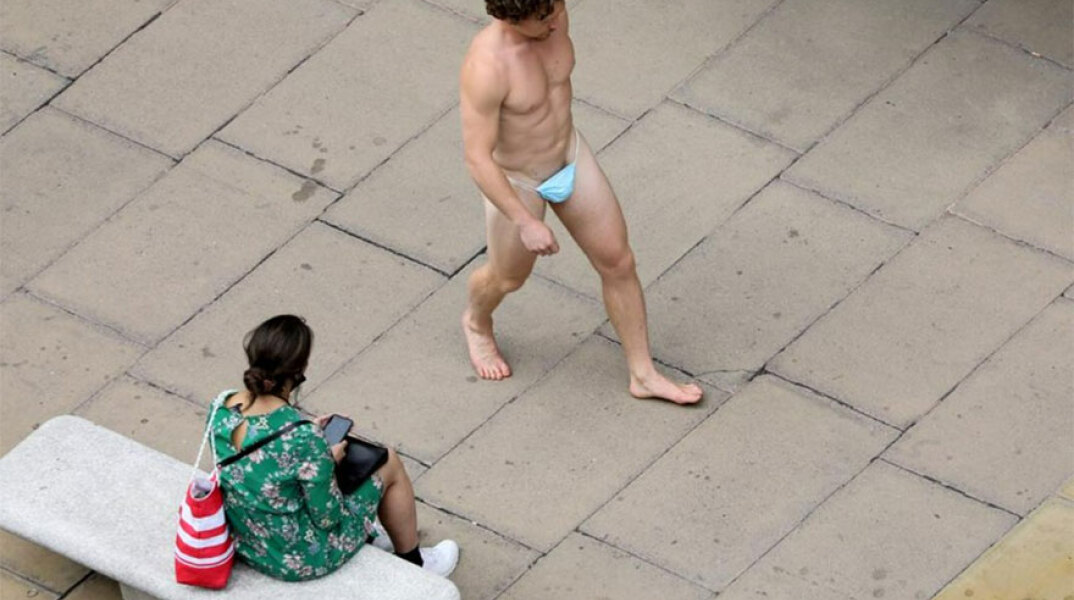 Γυμνός άνδρας στην Όξφορντ Στριτ, στο Λονδίνο, περπατά με μια μάσκα για τον κορωνοϊό στα γεννητικά όργανα