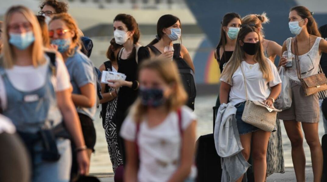 Άνθρωποι με μάσκα στο λιμάνι του Πειραιά 