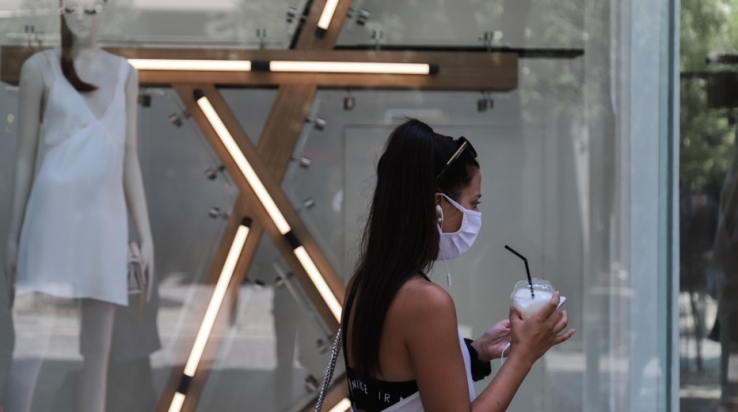 Μία κοπέλα με μάσκα και καφέ