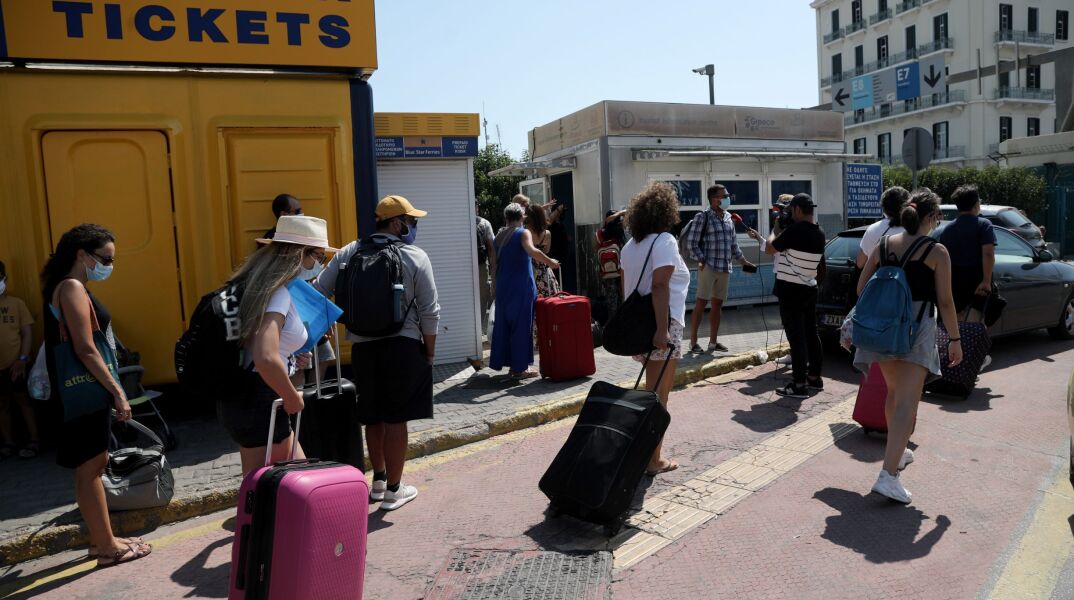 Άνθρωποι με μάσκα στο λιμάνι του Πειραιά 