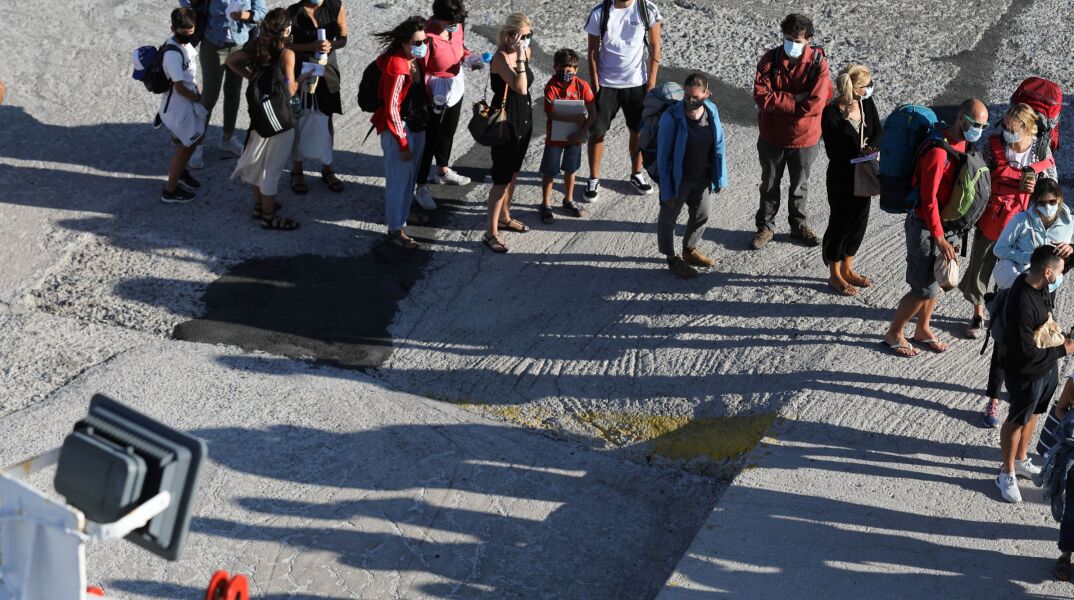 Άνθρωποι με μάσκα στο λιμάνι του Πειραιά 