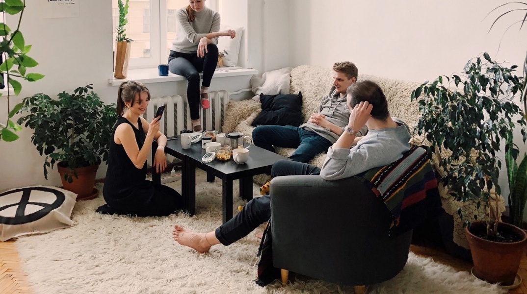 Αγόρια και κορίτσια αράζουν στο σαλόνι ενός σπιτιού