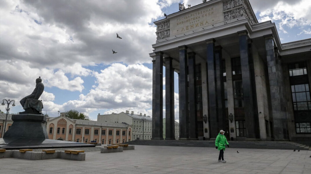Κορωνοϊός στη Ρωσία: Άνδρας με μάσκα περπατά μπροστά από τη βιβλιοθήκη Λένιν στη Μόσχα