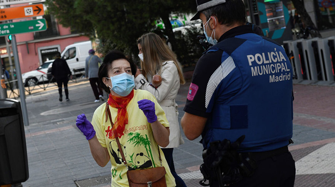 Αστυνομικός στη Μαδρίτη συνομιλεί με κάτοικο της πρωτεύουσας - Σε ισχύ τα νέα έκτακτα περιοριστικά μέτρα για τον κορωνοϊό