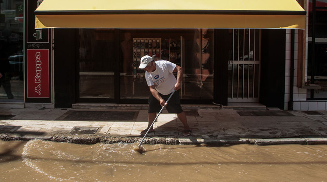 Πλημμύρες στην Καρδίτσα - Κάτοικος με τη σκούπα στα χέρια προσπαθεί να απομακρύνει τις λάσπες