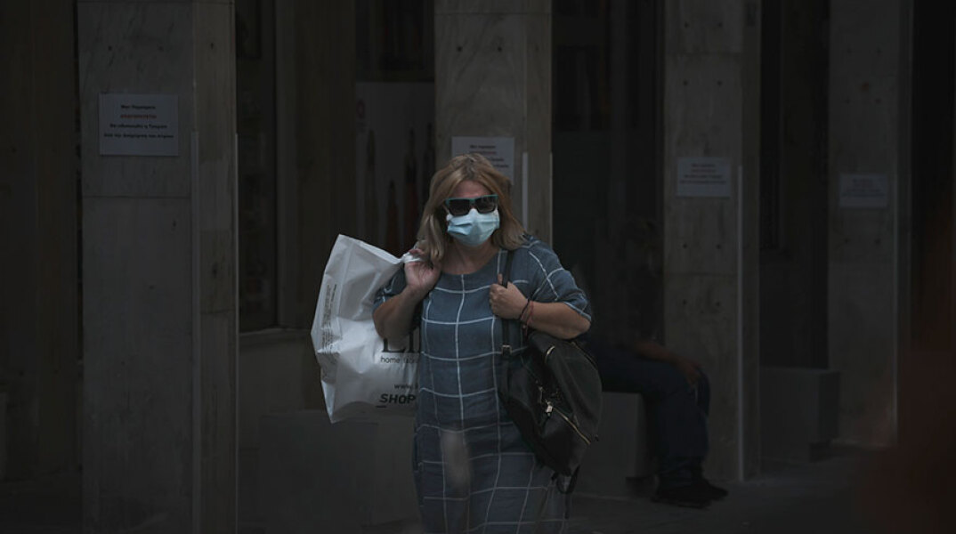 Γυναίκα με προστατευτική μάσκα για τον κορωνοϊό στο κέντρο της Αθήνας
