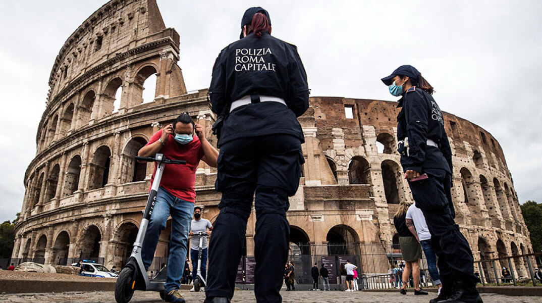 Κορωνοϊός στην Ιταλία: Αστυνομικοί κάνουν έλεγχο για τη χρήση μάσκας μπροστά από το Κολοσσαίο στη Ρώμη