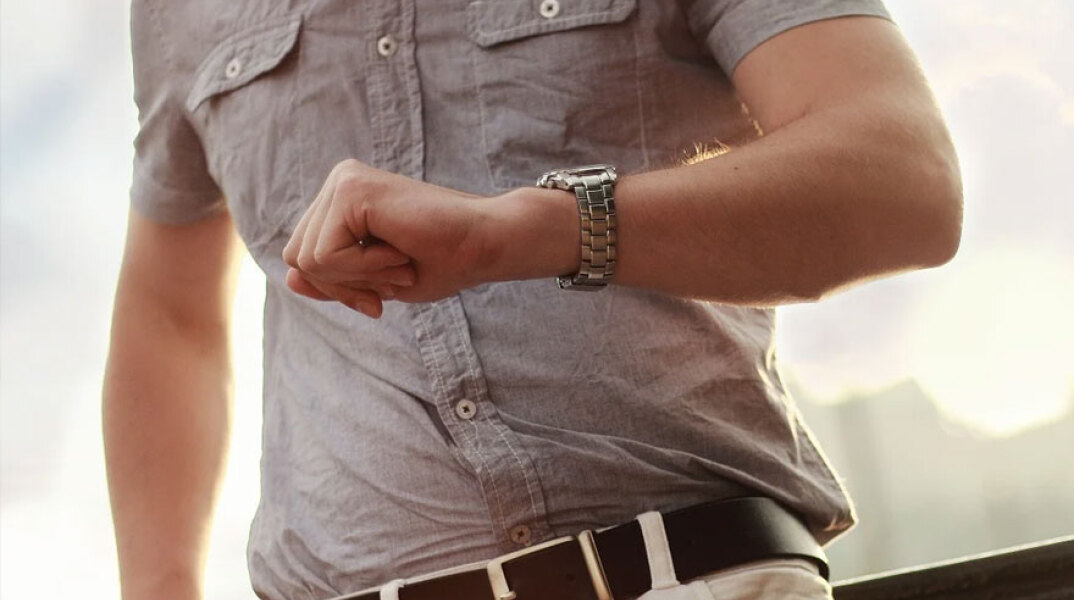 Άνδρας κοιτάει το ρολόι του - Πότε γίνεται η αλλαγή ώρας