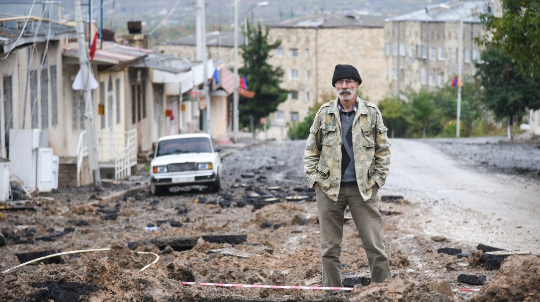 Πολίτης στέκεται σε συντρίμμια στην περιοχή Ναγκόρνο-Καραμπάχ