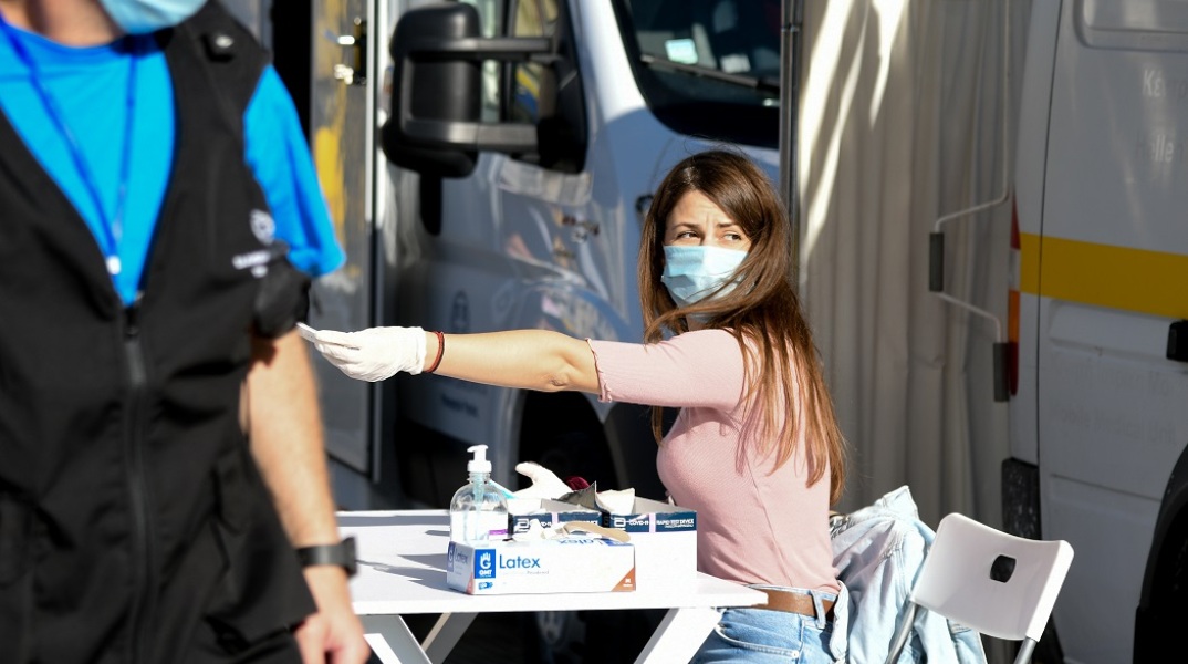 Κοπέλα με μάσκα κατά τη διεξαγωγή rapid test από τον ΕΟΔΥ