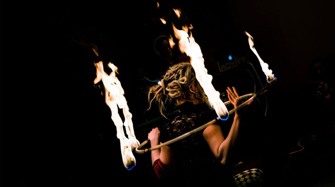 Καλλιτέχνης εκτελεί νούμερο με φωτιές και ένα στεφάνι