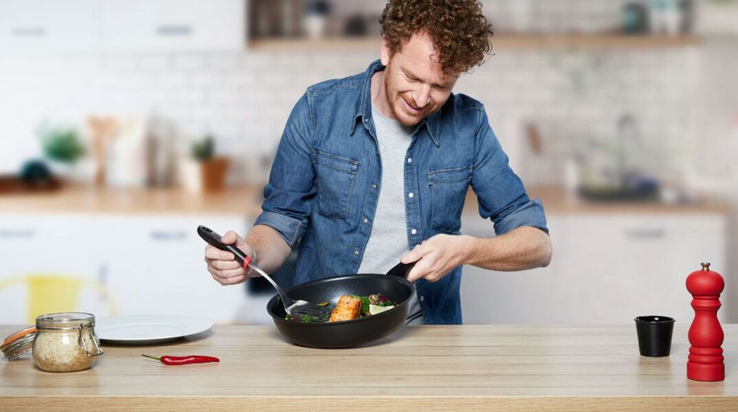 Άνδρας σε κουζίνα κρατάει τηγάνι από τη σειρά Tefal Unlimited