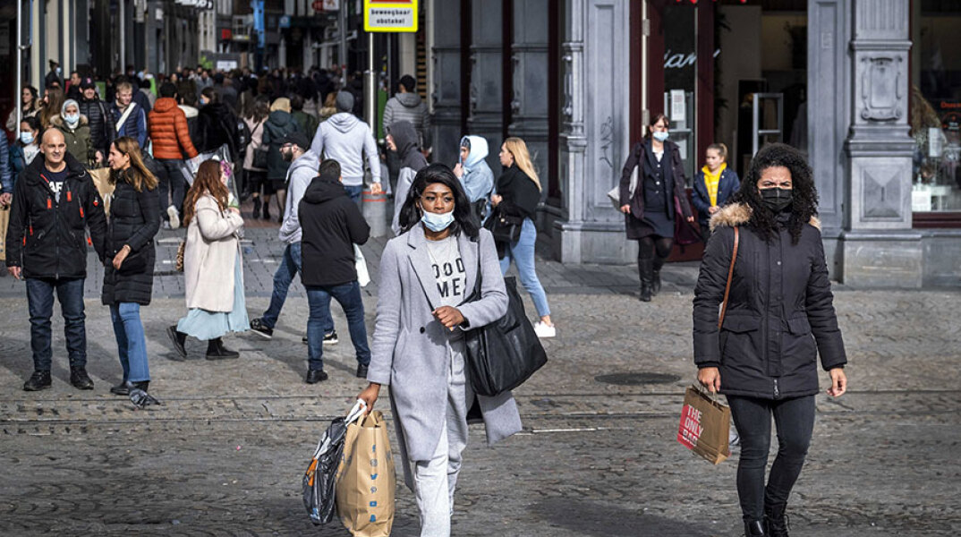 Πολίτες με σακούλες από ψώνια σε κεντρικό δρόμο του Άμστερνταμ