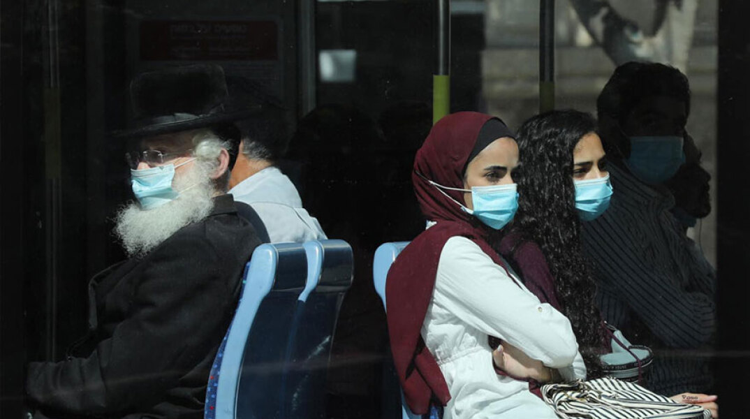 Επιβάτες σε λεωφορείο με προστατευτική μάσκα για τον κορωνοϊό στο Ισραήλ