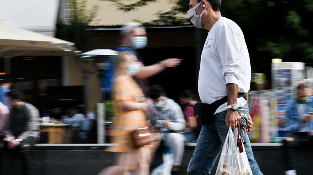 Πολίτες με μάσκα για τον κορωνοϊό στο κέντρο της Αθήνας