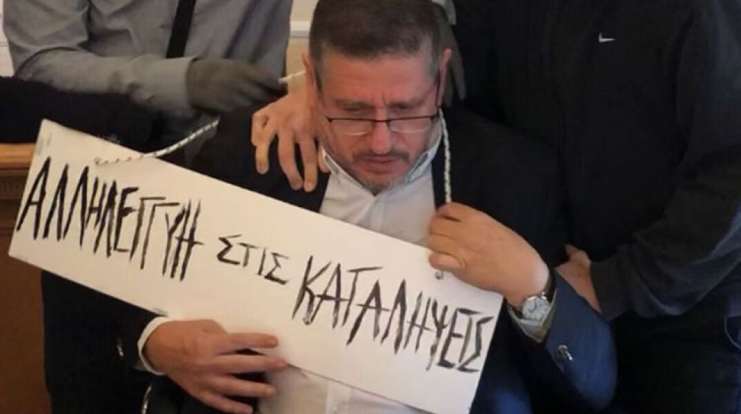 Ο πρύτανης του ΟΠΑ με την ταμπέλα που του κρέμασαν αναρχικοί στον λαιμό