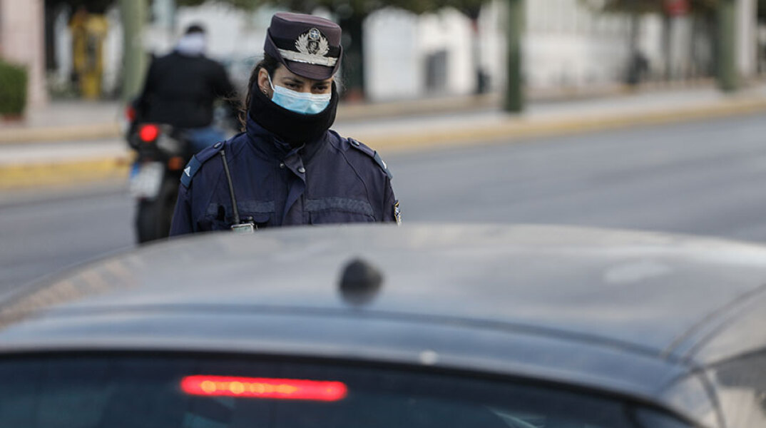 Αστυνομικός πραγματοποιεί έλεγχο για τις μετακινήσεις εν μέσω νέου lockdown στο κέντρο της Αθήνας