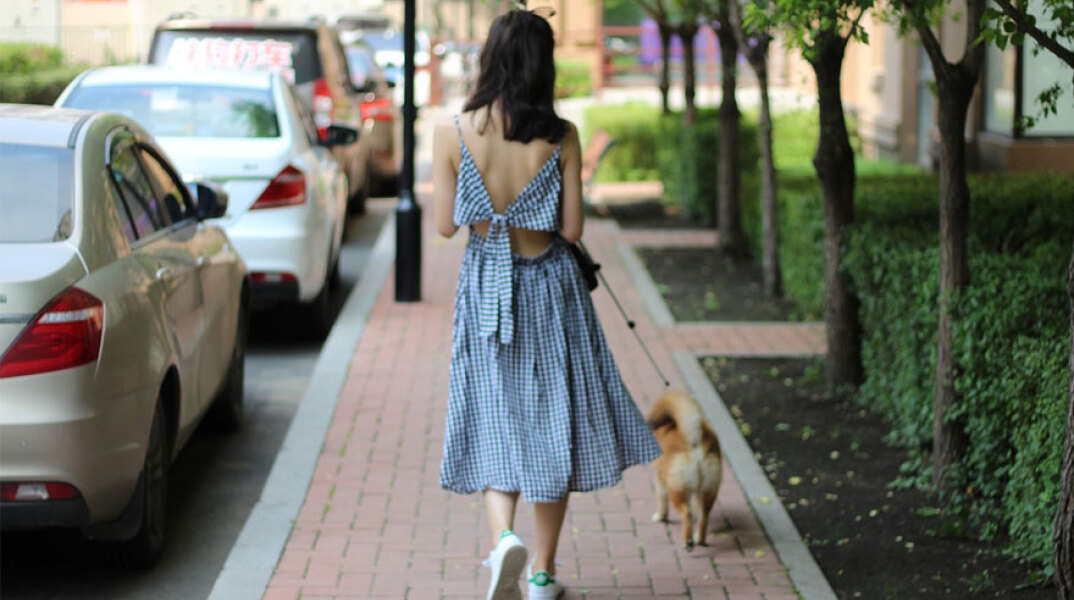 Γυναίκα βγάζει βόλτα τον σκύλο της