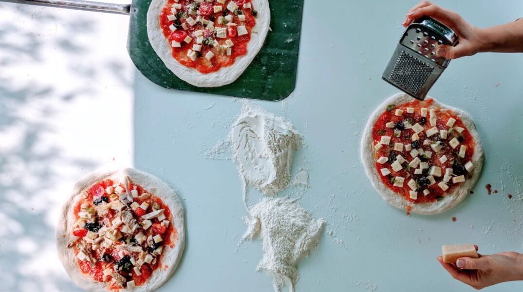 Γυναίκα φτιάχνει σπιτική πίτσα