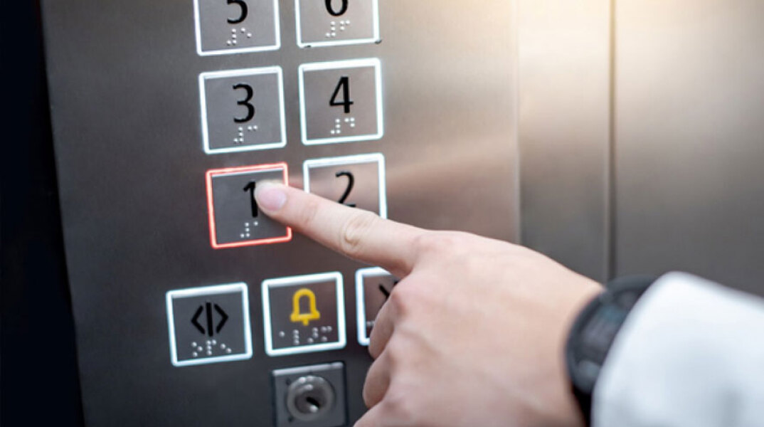 Άνδρας πατά το κουμπί σε ανελκυστήρα
