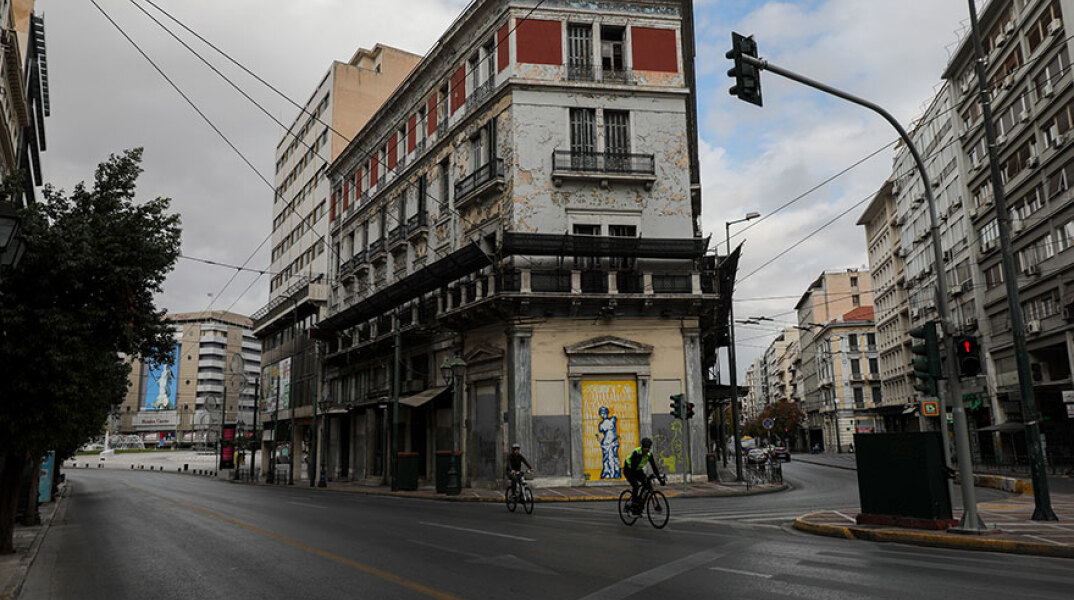 Ποδηλάτες σε έρημο δρόμο στο κέντρο της Αθήνας εν μέσω lockdown για τον κορωνοϊό