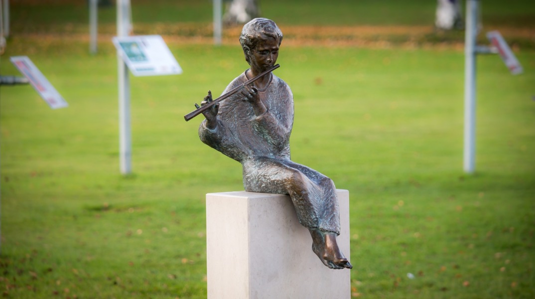 Μπρούτζινο άγαλμα παιδιού που παίζει φλάουτο