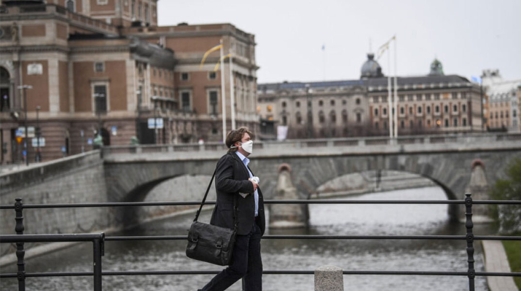 Στοκχόλμη: Άνδρας με προστατευτική μάσκα για τον κορωνοϊό διασχίζει γέφυρα στην πρωτεύουσα της Σουηδίας
