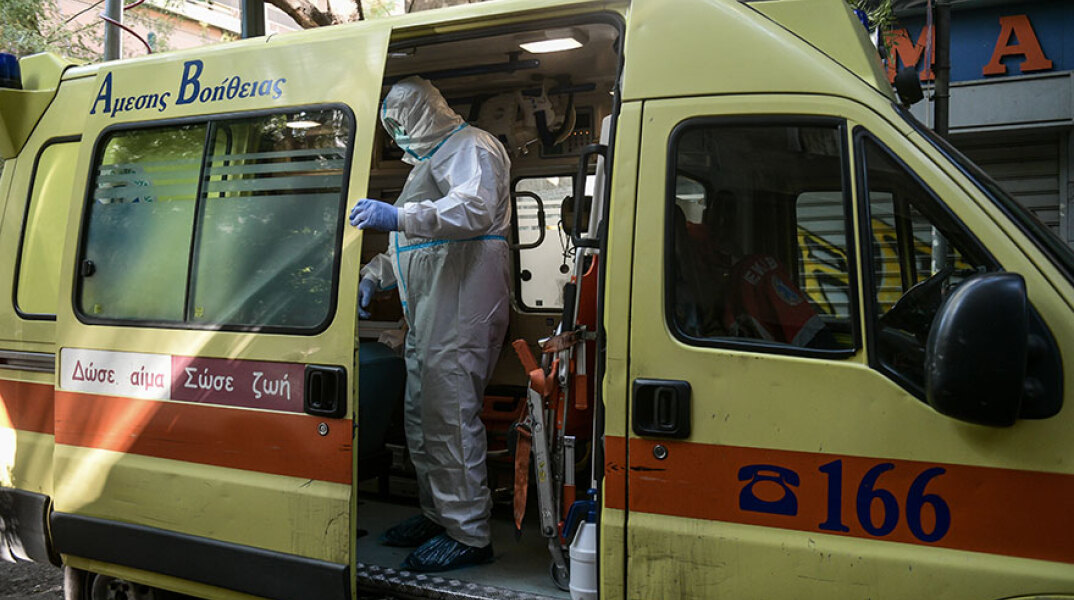 Τραυματιοφορέας σε ασθενοφόρο του ΕΚΑΒ με προστατευτική στολή για τον κορωνοϊό