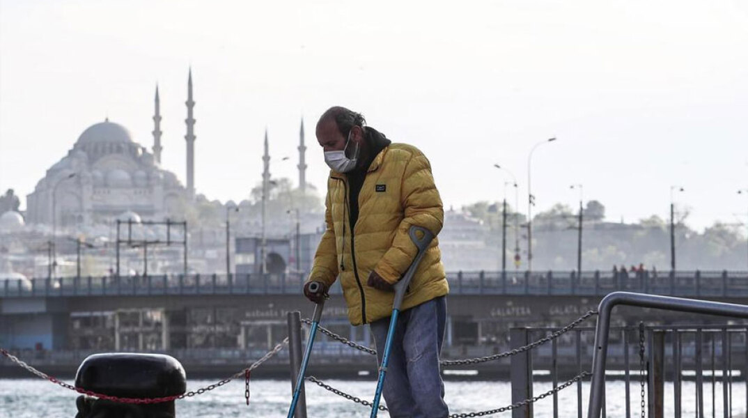 Άνδρας με πατερίτσα και προστατευτική μάσκα για τον κορωνοϊό στην Κωνσταντινούπολη