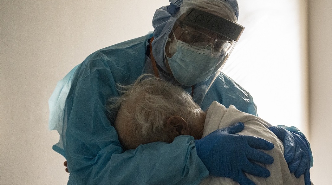 Γιατρός σε κλινική covid αγκαλιάζει ηλικιωμένο ασθενή 