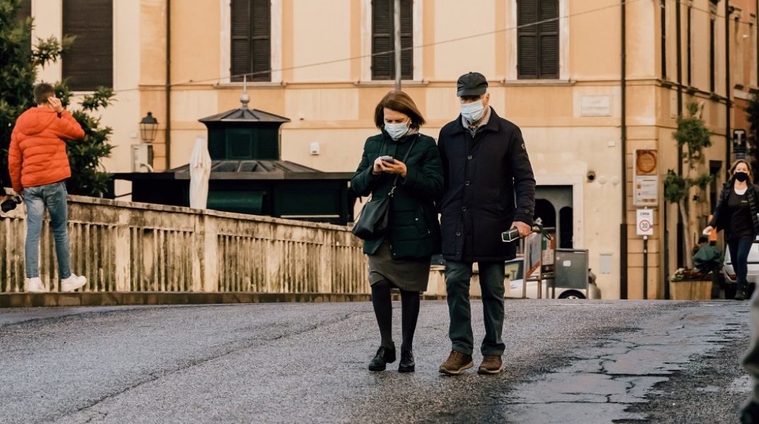 Πολίτες με μάσκα σε δρόμο της Ιταλίας