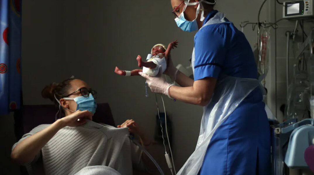 Νοσηλεύτρια δίνει το νεογέννητο μωρό στη μητέρα του