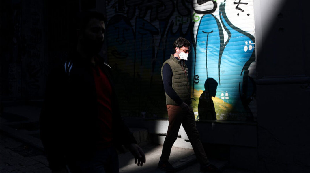 Κάτοικος στην Κωνσταντινούπολη με μάσκα για τον κορωνοϊό περνά μπροστά από κλειστό κατάστημα
