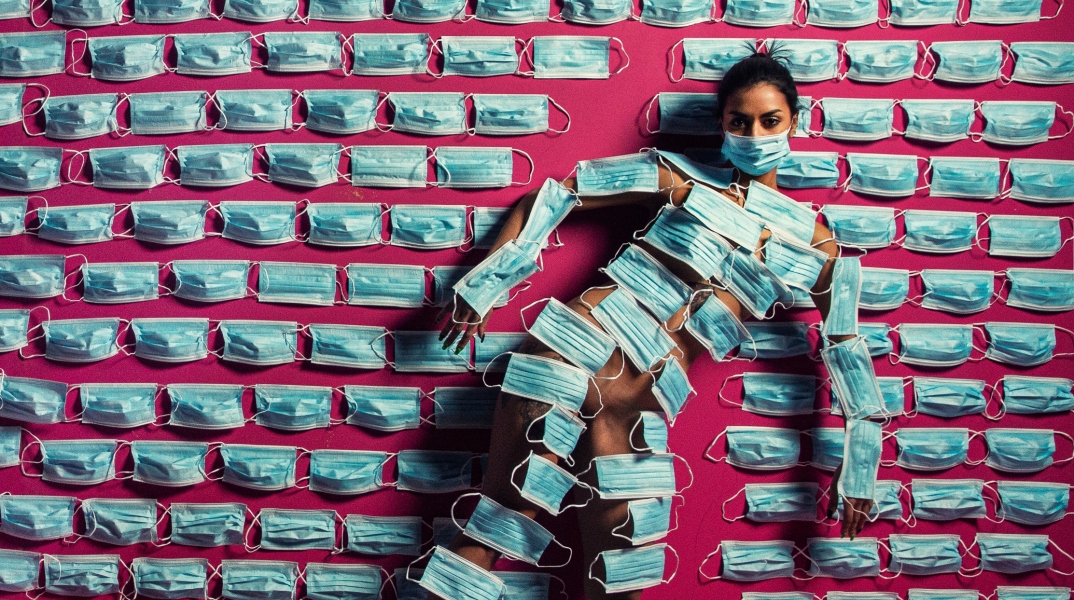 Γυναίκα που έχει καλύψει το σώμα της με μάσκες προστασίας