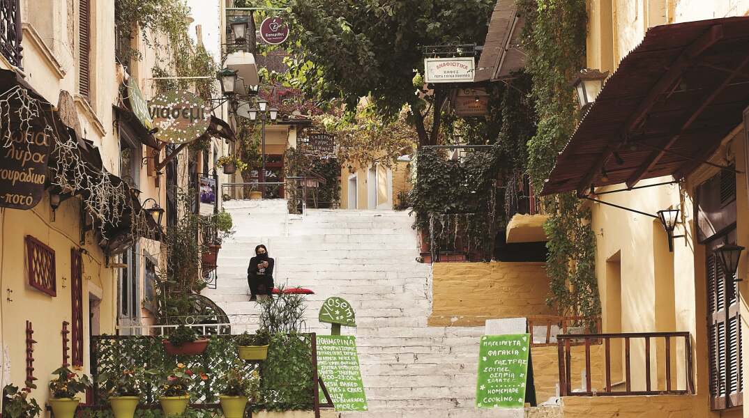 Γυναίκα με μάσκα που κάθεται σε σκαλιά στην περιοχή Αναφιώτικα στην Αθήνα κατά την περίοδο του lockdwon