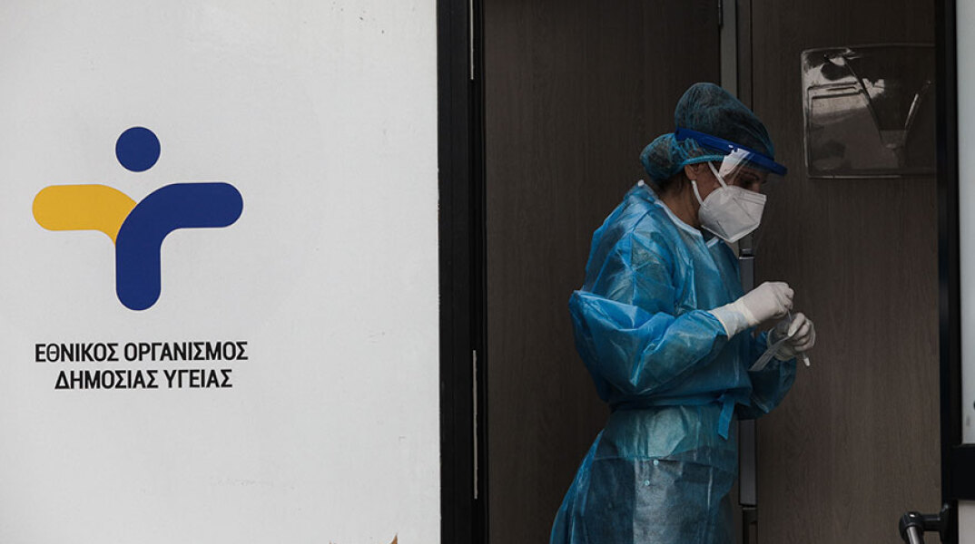 Εργαζόμενη σε κλιμάκιο του ΕΟΔΥ με προστατευτική στολή και μάσκα για τον κορωνοϊό διενεργεί rapid test