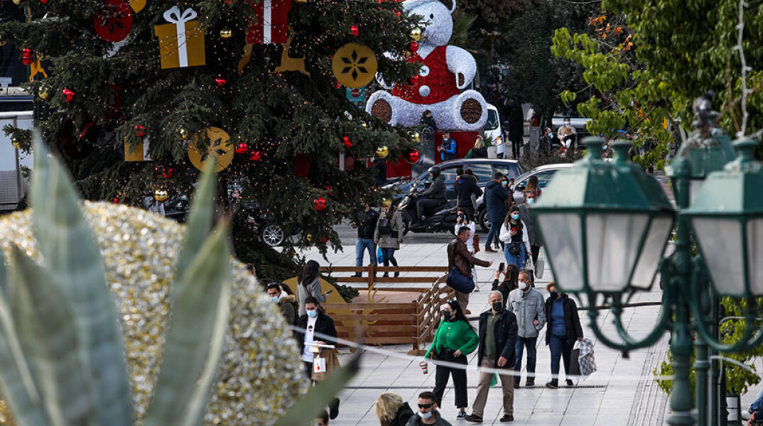 Lockdown στην Αθήνα: Πολίτες στη χριστουγεννιάτικη στολισμένη πλατεία Συντάγματος - Στο βάθος η αρχή της Ερμού