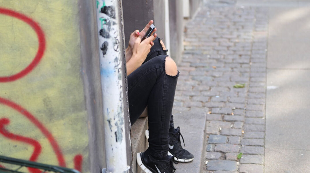 Νεαρό άτομο με κινητό τηλέφωνο