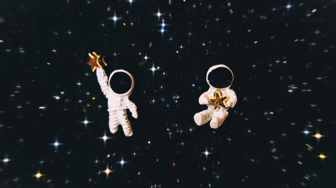 Φιγούρες αστροναυτών με φόντο αστέρια