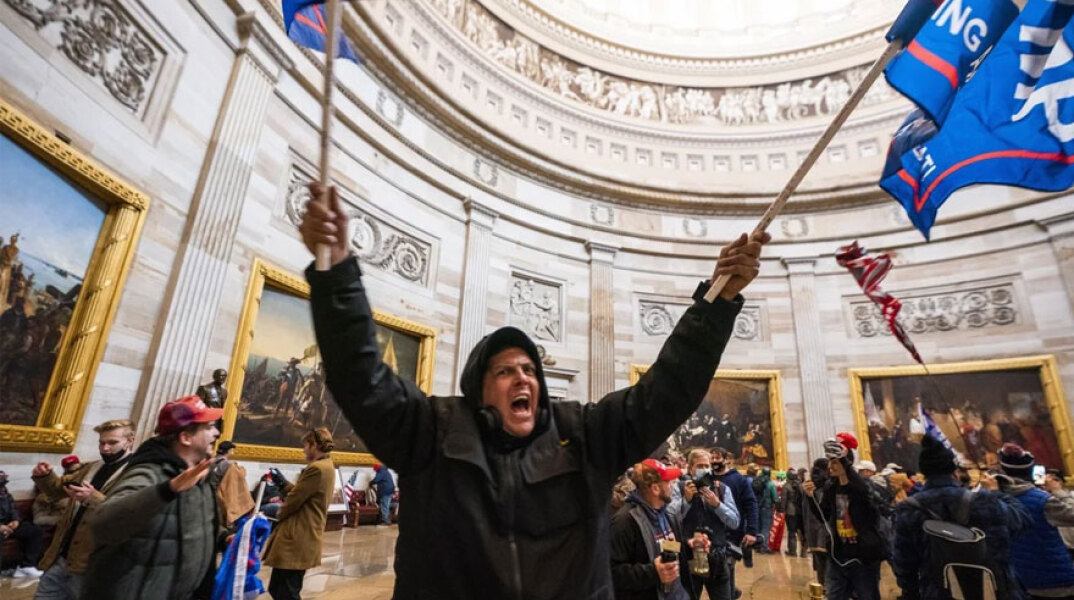 Καπιτώλιο: Μαινόμενος διαδηλωτής του Ντόναλντ Τραμπ με σημαίες στα χέρια φωνάζει σε αίθουσα του κτιρίου κατά την εισβολή