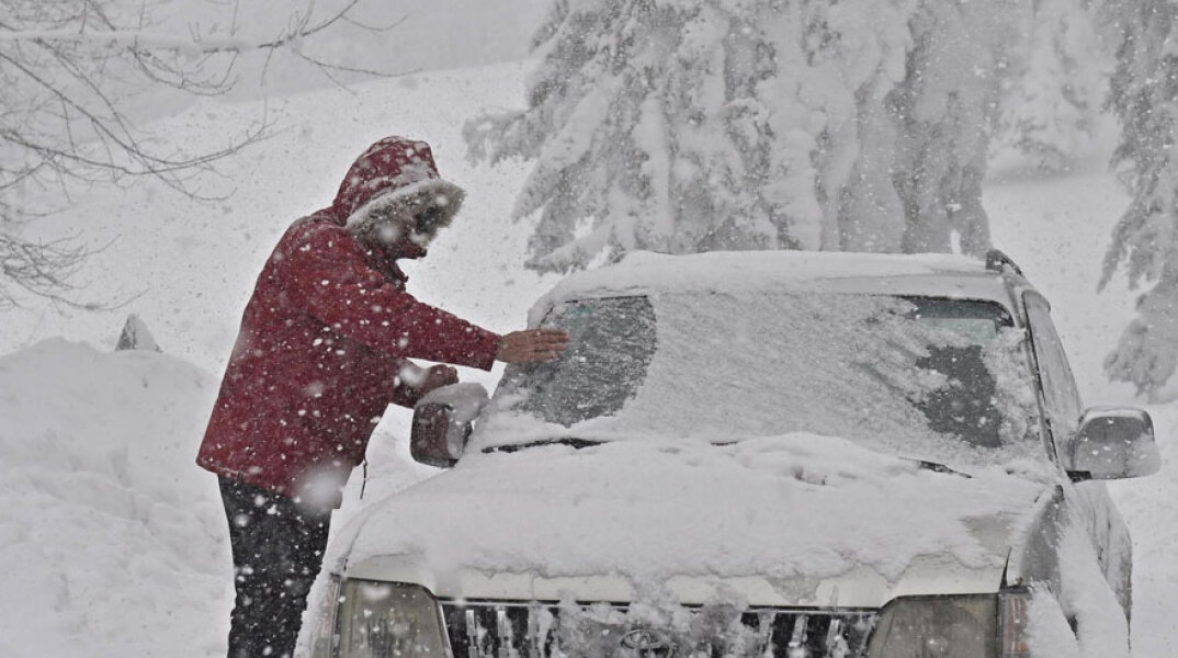 Οδηγός απομακρύνει το χιόνι από αυτοκίνητο (ΦΩΤΟ ΑΡΧΕΙΟΥ) - Οι μετεωρολόγοι προειδοποιούν για σφοδρές χιονοπτώσεις στη Μαδρίτη