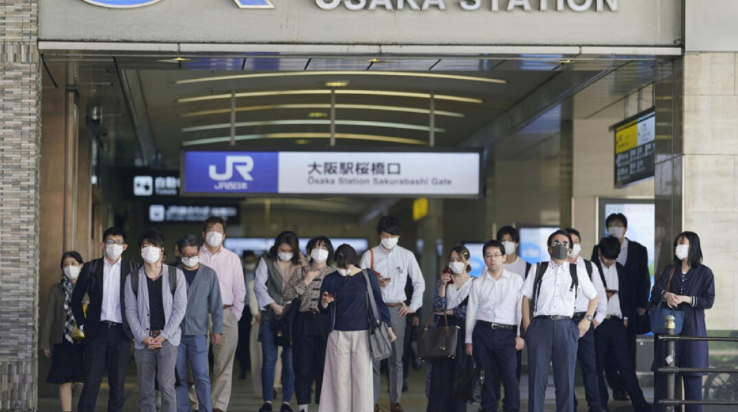 Πολίτες στην Ιαπωνία με μάσκα για τον κορωνοϊό περιμένουν το τρένο