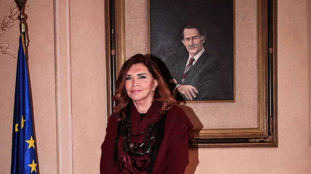 Η Mιμή Ντενίση με φόντο πορτραίτο του Αντώνη Τρίτση στο Δημαρχείο Αθηνών