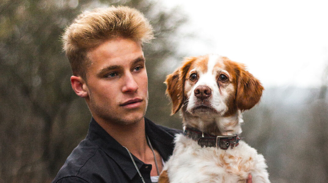 Άντρας που κρατάει σκύλο