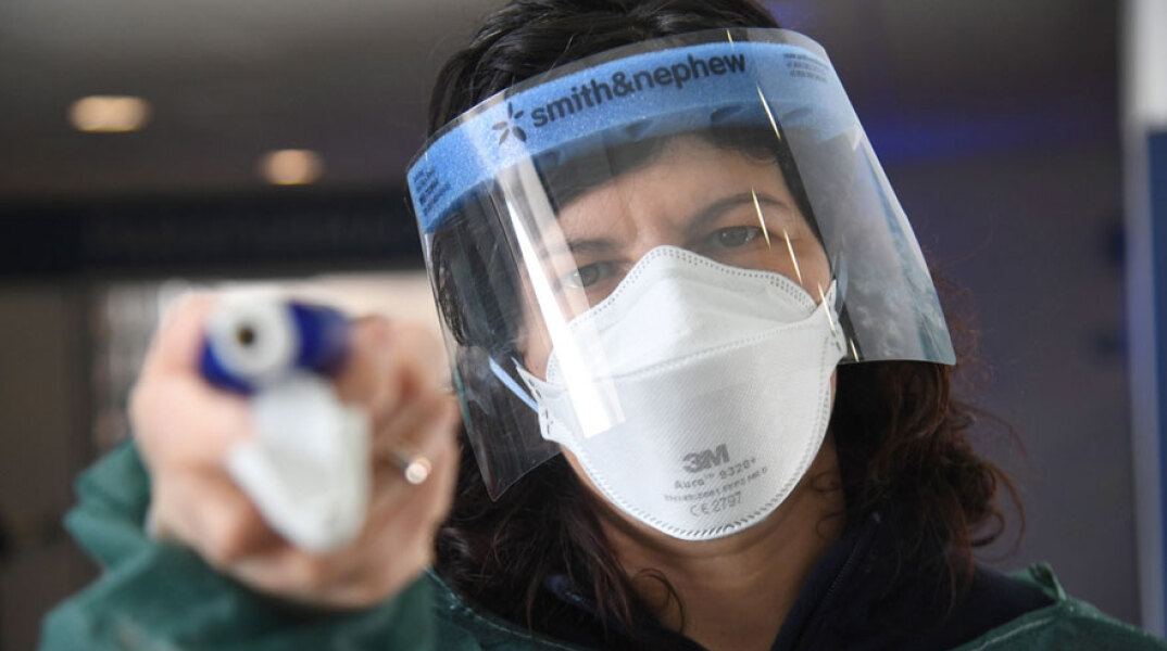 Πορτογαλία: Γυναίκα με μάσκα και ασπίδα για τον κορωνοϊό
