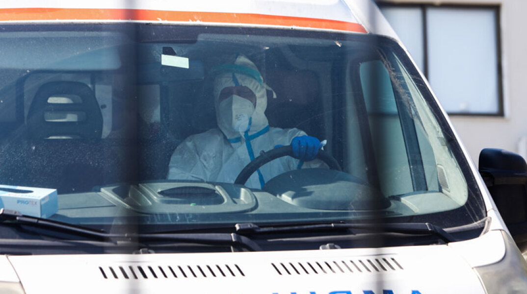 Οδηγός σε ασθενοφόρο του ΕΚΑΒ με προστατευτική στολή για τον κορωνοϊό