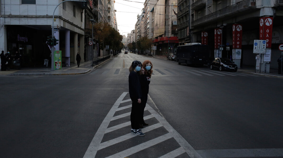 Με κλειστό λιανεμπόριο το σκληρό lockdown στην Αττική μέχρι την Κυριακή 28 Φεβρουαρίου 2021 - Κοπέλες με μάσκα σε έρημο δρόμο στο κέντρο της Αθήνας
